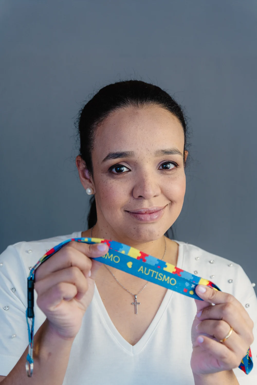 Dra. Louise Lima segurando um cordão de identificação do autismo