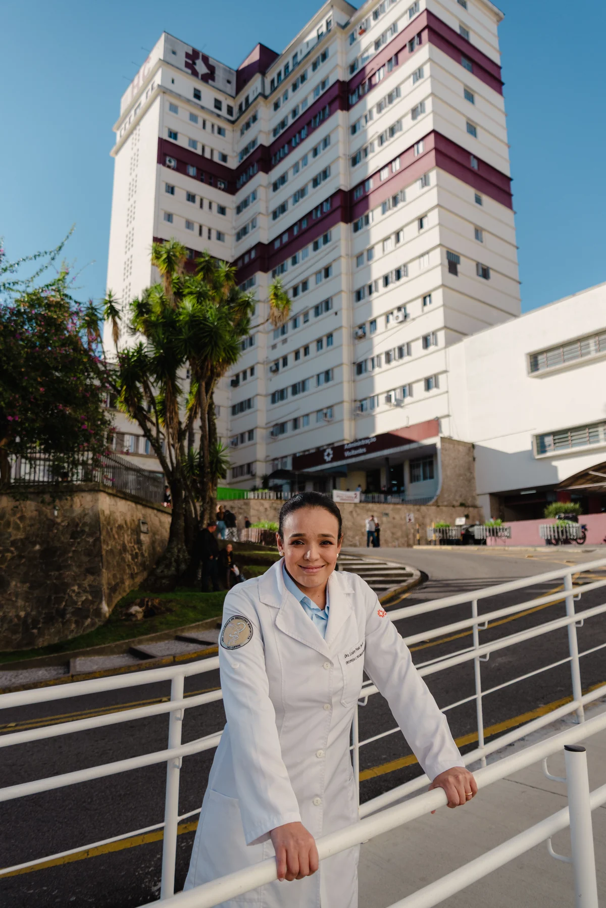 Dra. Louise Lima em frente a um hospital, durante sua atuação na área da saúde